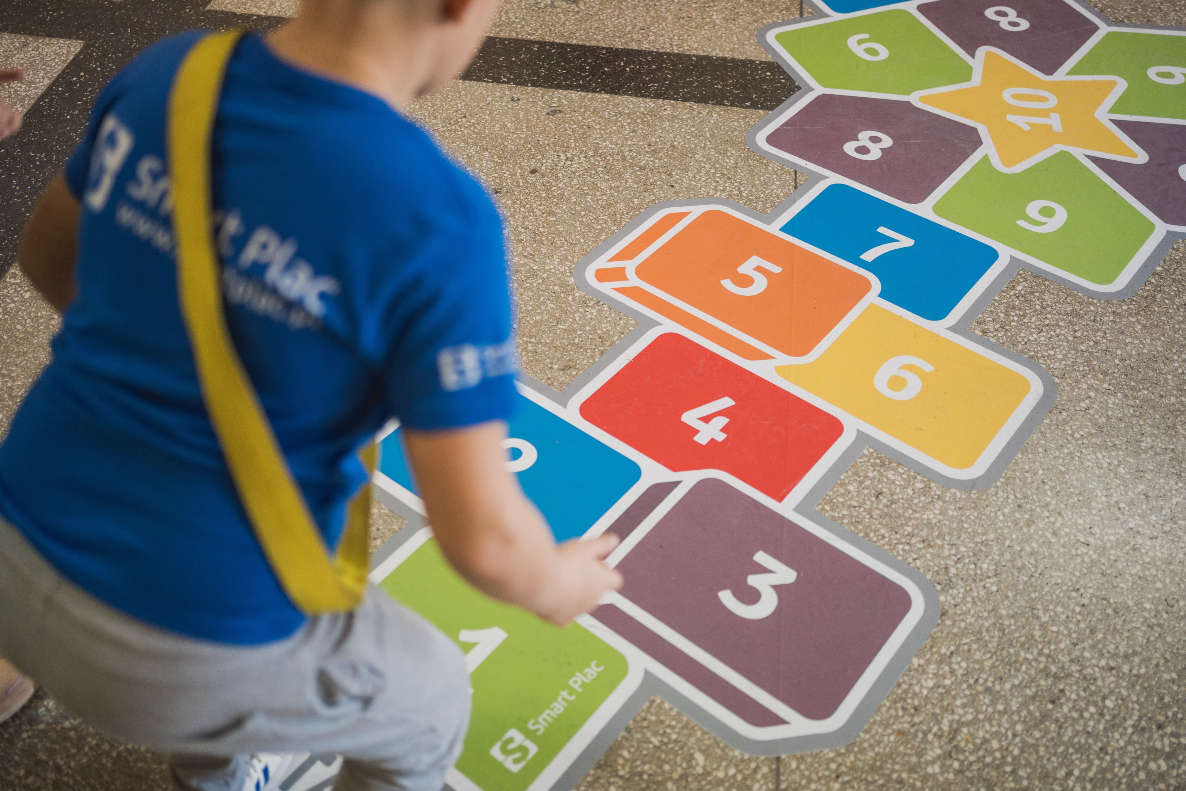 dziecko bawiące się na naklejce korytarzowej