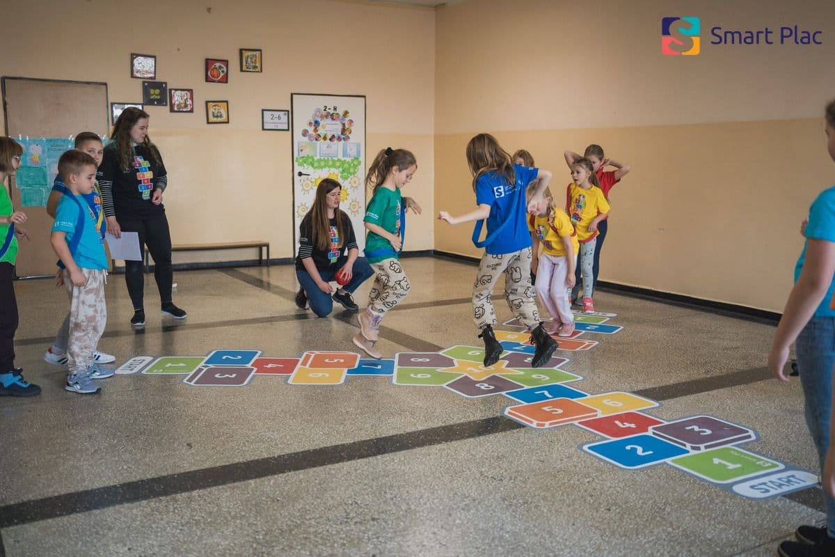 Zdjęcie bawiących się dzieci na naklejce korytarzowej.